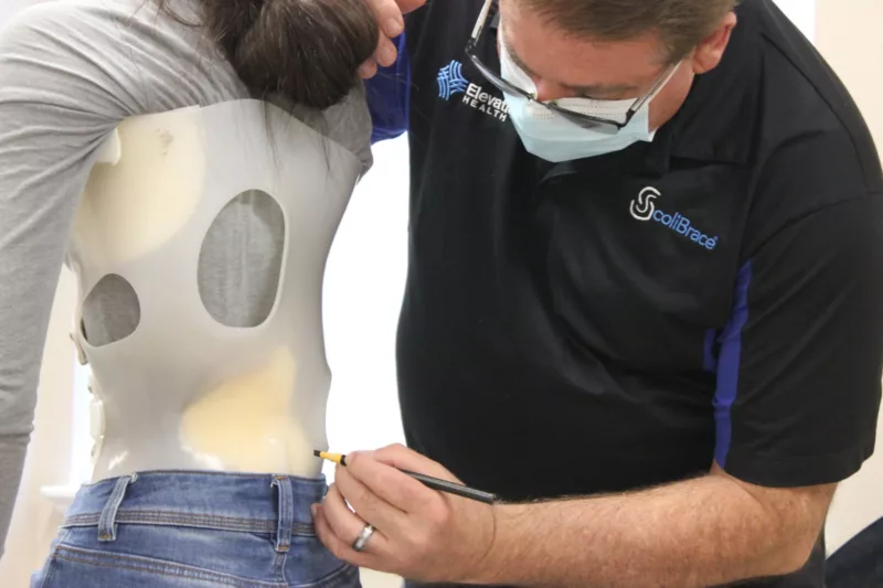 Dr Gary Lee Chiropractor measuring Scolibrace brace