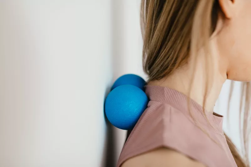 side profile pic of female head with 2 plastic blue balls behind her neck